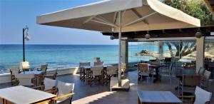 a restaurant with tables and chairs and the ocean at Irides in Souvala