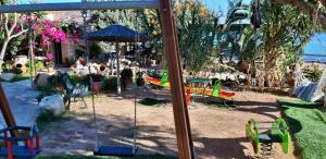 a group of swings in a garden with plants at Irides in Souvala