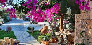 a garden with pink flowers and tables and plants at Irides in Souvala