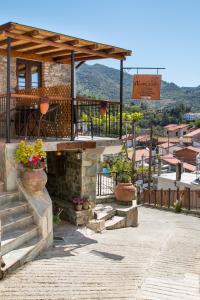 een gebouw met een veranda en een trap met bloemen bij AgroSpito Traditional Guest House in Agros