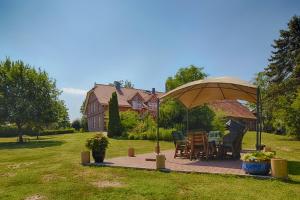 a patio with a table and an umbrella in a yard at Elbhof Harnisch in Bleckede