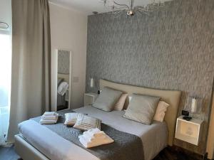 een slaapkamer met een bed met twee handdoeken erop bij Gatto Bianco Le Mura in Bergamo