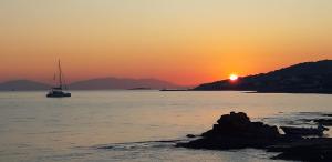 a boat in the ocean with the sun setting in the background at Irides in Souvala