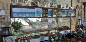 a window with many vases on a counter with flowers at Irides in Souvala