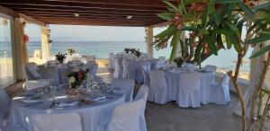 a room with white tables and chairs and the ocean at Irides in Souvala
