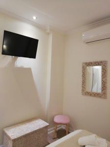 Schlafzimmer mit einem Flachbild-TV an der Wand in der Unterkunft Don Cecilio Guesthouse (Parte Vieja) in San Sebastián