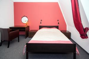 um quarto com uma cama, um espelho e uma cadeira em Apartamenty Wratislavia em Breslávia mais 16 fotografias