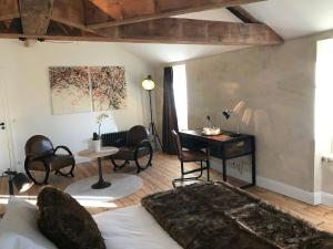 a living room with a bed and a table and chairs at Le Clos des Queyries, Chambres d'Hôtes in Bordeaux
