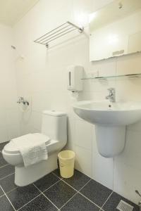 馬公市的住宿－幸福花民宿 ，白色的浴室设有卫生间和水槽。