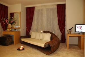 a living room with a wicker chair in front of a window at Park Hotel Sandanski in Sandanski