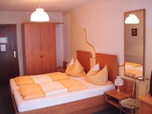 a bedroom with a bed with orange and white pillows at Pension Dreiländereck in Birx