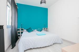 a bedroom with a white bed with a blue wall at La casa di Marta in Genova