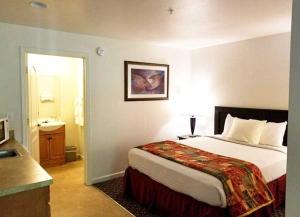 a hotel room with a bed and a bathroom at Northern Queen Inn in Nevada City