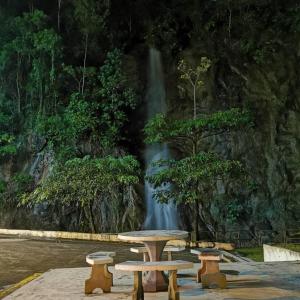 a table and benches in front of a waterfall at Mr.J Homestay in Taiping