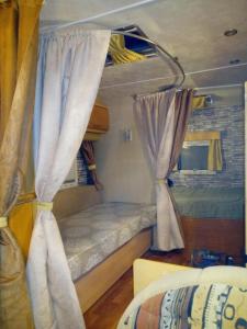 Habitación pequeña con 2 literas y cortinas en Camping Pitsoni, en Sikia