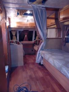 um quarto com 2 beliches e piso em madeira em Camping Pitsoni em Sikia