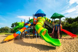 a playground with a slide in the sand at Le Dune Residence in Cavallino-Treporti