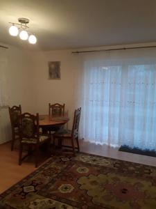ein Esszimmer mit einem Tisch, Stühlen und einem Fenster in der Unterkunft Ferienwohnung Mayer in Kirchheim am Ries