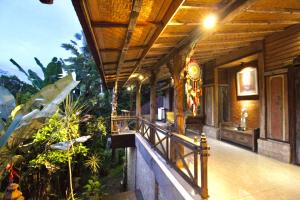 a porch of a building with a wooden roof at Umah Nik Kepitu in Gianyar
