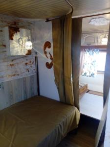 Una cama en una habitación con una serpiente en la pared en Camping Pitsoni, en Sikia