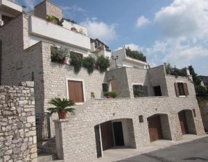 a stone building with potted plants on top of it at Le Camere Pinte in Sermoneta