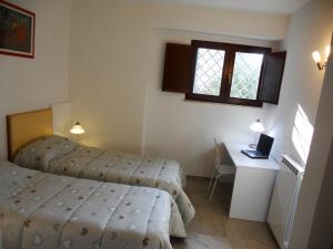 a bedroom with two beds and a desk and a window at Le Camere Pinte in Sermoneta