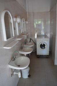 y baño con 2 lavabos y lavadora. en Camping Pitsoni, en Sikia