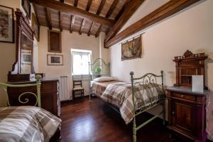 sypialnia z 2 łóżkami i drewnianą podłogą w obiekcie Casa Spagnoli w Asyżu