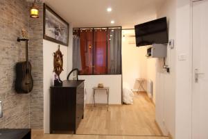 a living room with a guitar and a television in it at Le Poilu 40 m2 in La Ciotat