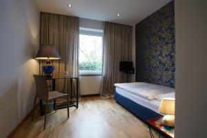 ein Hotelzimmer mit einem Bett und einem Fenster in der Unterkunft Hotel Stern in Düsseldorf