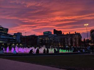 a group of people sitting around a fountain at sunset at QuickSpaces Heart of the City in Manchester