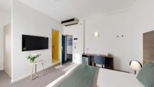 1 dormitorio con 1 cama y TV de pantalla plana en Hotel Villa Sorriso, en Lido di Jesolo