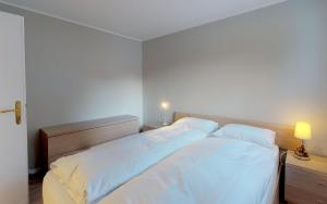 サンモリッツにあるBalcun Tort 9のベッドルーム(白いシーツを使用した大型ベッド1台付)