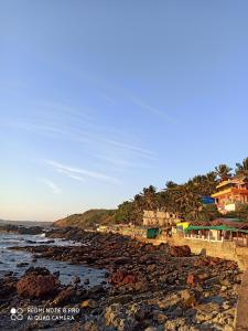 ein Strand mit einigen Häusern und dem Meer in der Unterkunft Om Ganesh Naik Guest House in Arambol