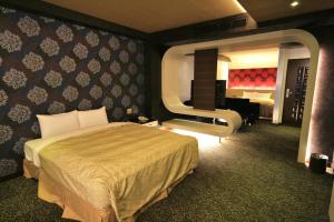 Habitación de hotel con cama y espejo grande en Fairy Tale City Motel en Hualien