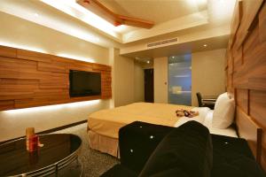 ein Hotelzimmer mit einem Bett und einem Flachbild-TV in der Unterkunft Fairy Tale City Motel in Hualien