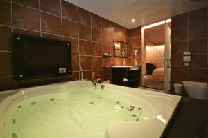 a large bath tub with a television in a bathroom at Fairy Tale City Motel in Hualien City
