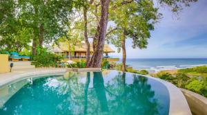 uma piscina com vista para o oceano em Hotel Boutique Lagarta Lodge em Nosara