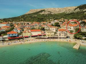a group of people swimming in the water at a beach at Apartment & Rooms Three Angels in Baška