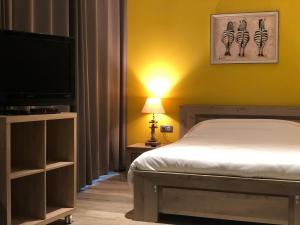 a bedroom with a bed and a flat screen tv at Hotel de l'Abbaye à Cluny in Cluny