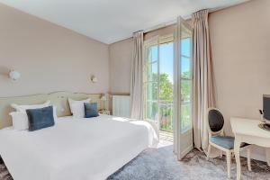 sypialnia z dużym białym łóżkiem i oknem w obiekcie Hôtel Le Maxime - Best Western Signature Collection w mieście Auxerre