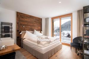 a bedroom with a bed and a large window at Boutique Lodge Spycher in Saas-Fee