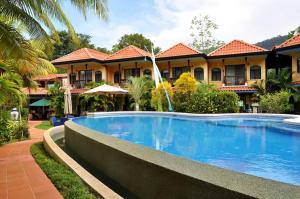 un hotel con piscina frente a un edificio en Hotel Cuna del Angel, en Uvita