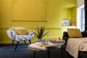 a living room with a couch and a chair and a table at Le Général d'Elbée Hotel & Spa - Teritoria in Noirmoutier-en-l'lle