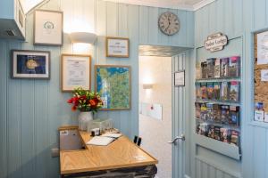 a room with a desk and a clock on the wall at Tudor Lodge in Porthmadog