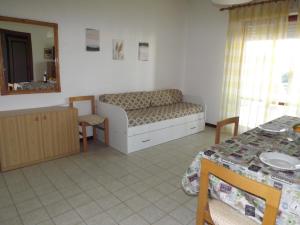 Zimmer mit einem Bett, einem Tisch und einem Spiegel in der Unterkunft Residenze Sul Mare in Martinsicuro