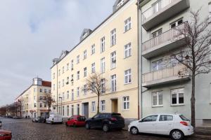 a white car parked in front of a building at Sweet Central Tiny Apartment for 4 People in Berlin