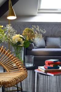 a living room with a couch and a table with books at Le Général d'Elbée Hotel & Spa - Teritoria in Noirmoutier-en-l'lle