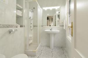 a white bathroom with a sink and a shower at Apartamentos Turísticos Casa Soto in Baiona