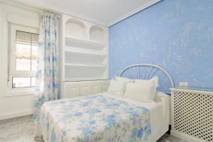 バイヨーナにあるApartamentos Turísticos Casa Sotoの青いベッドルーム(ベッド1台、窓付)